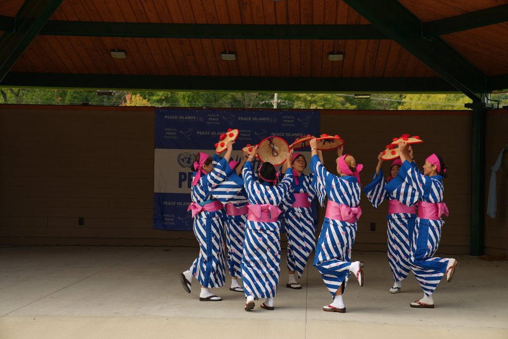 Dancers in striped costumes perform a traditional dance on the festival stage