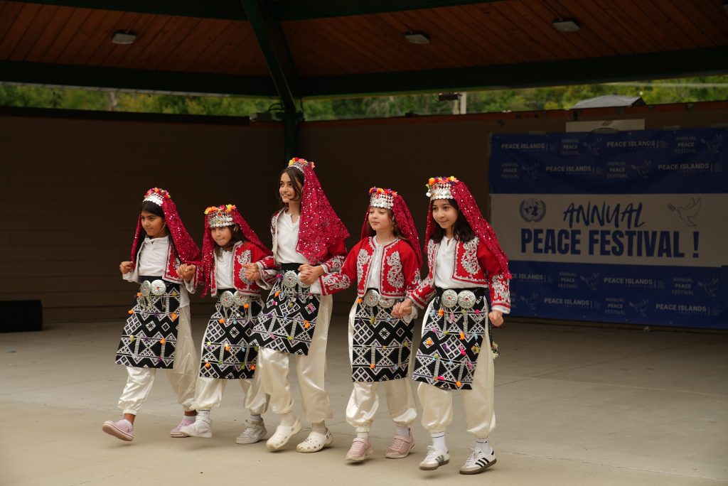 Children in traditional costumes perform a folk dance