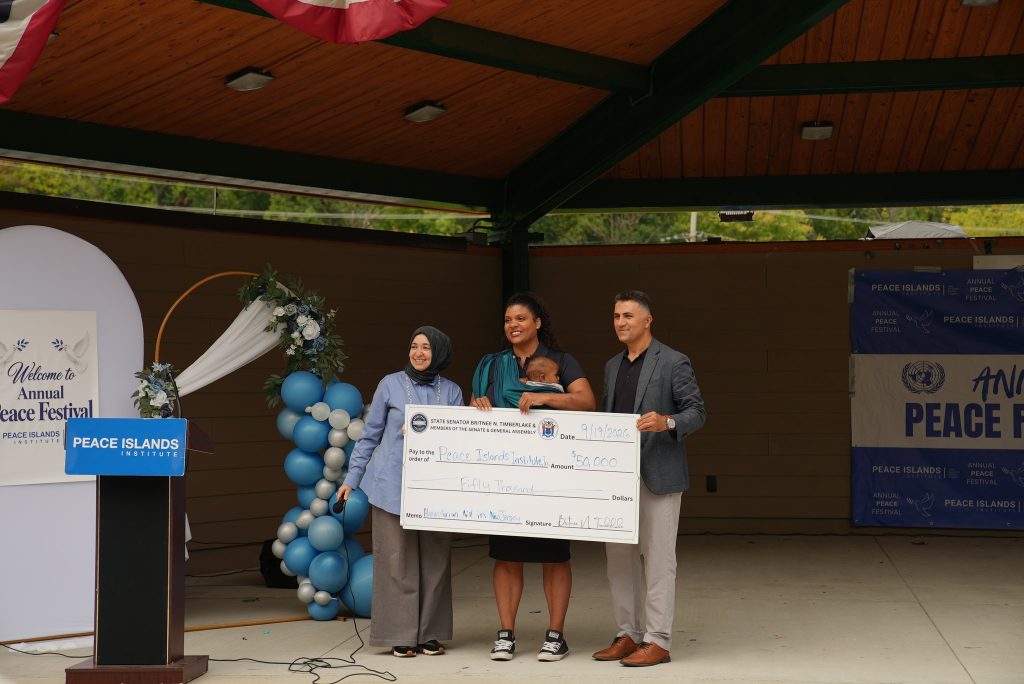 New Jersey State Senator Britnee N. Timberlake presents a $50,000 check to Peace Islands Institute