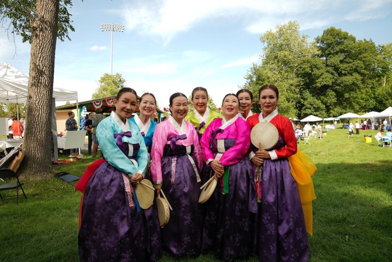 Dancers in colorful traditional dress pose together at the festival