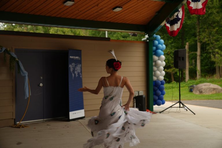 A dancer in a white gown performs on stage