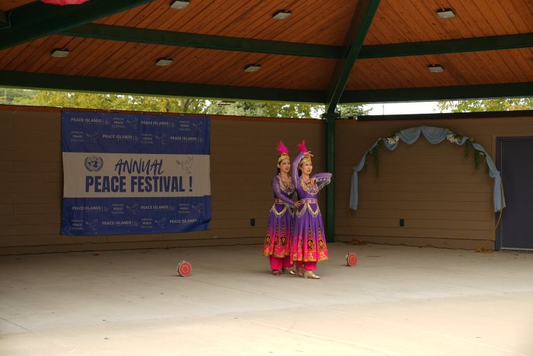 Two dancers in purple and pink costumes perform on stage