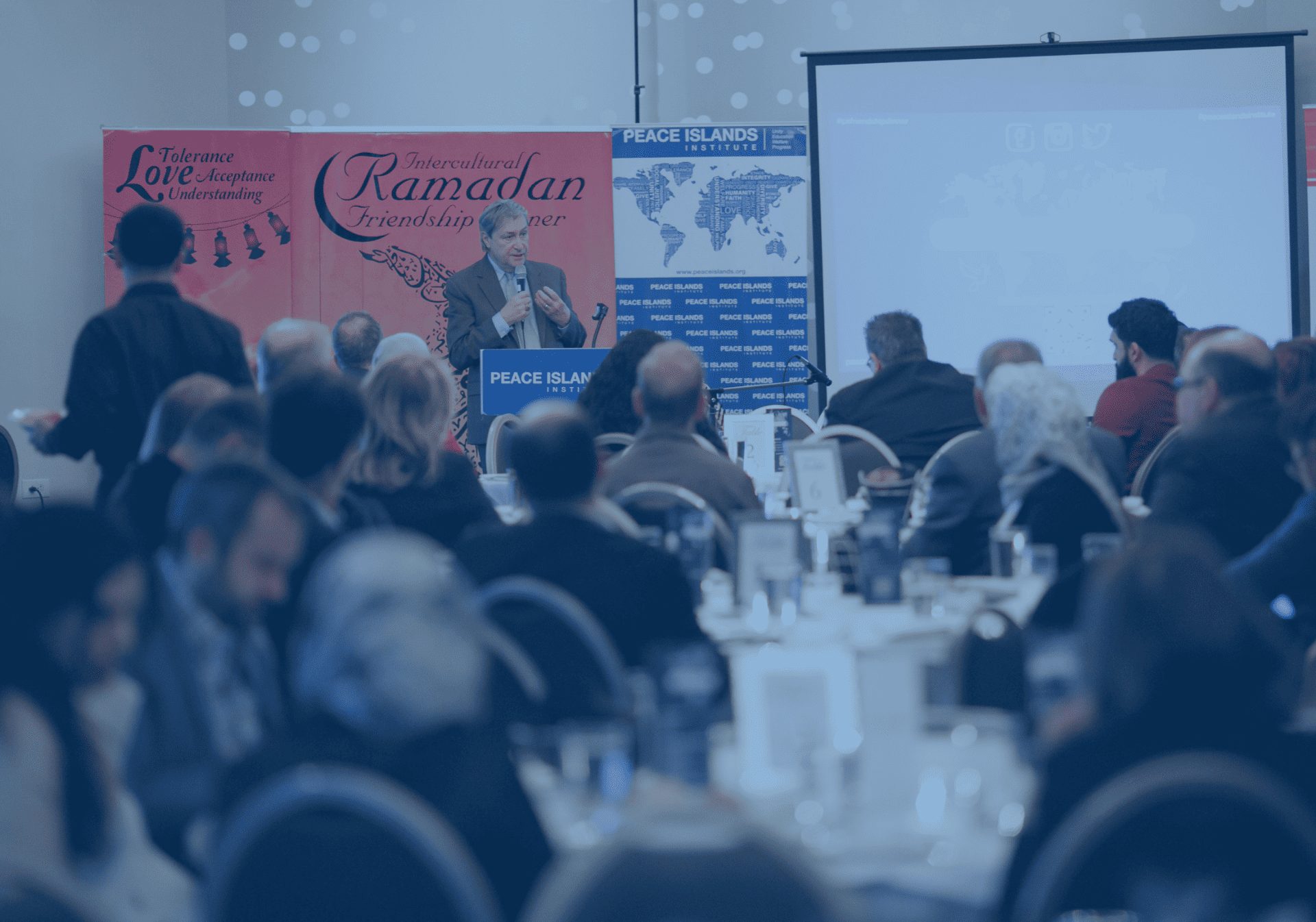 Guests listen to a speaker at a Ramadan friendship dinner
