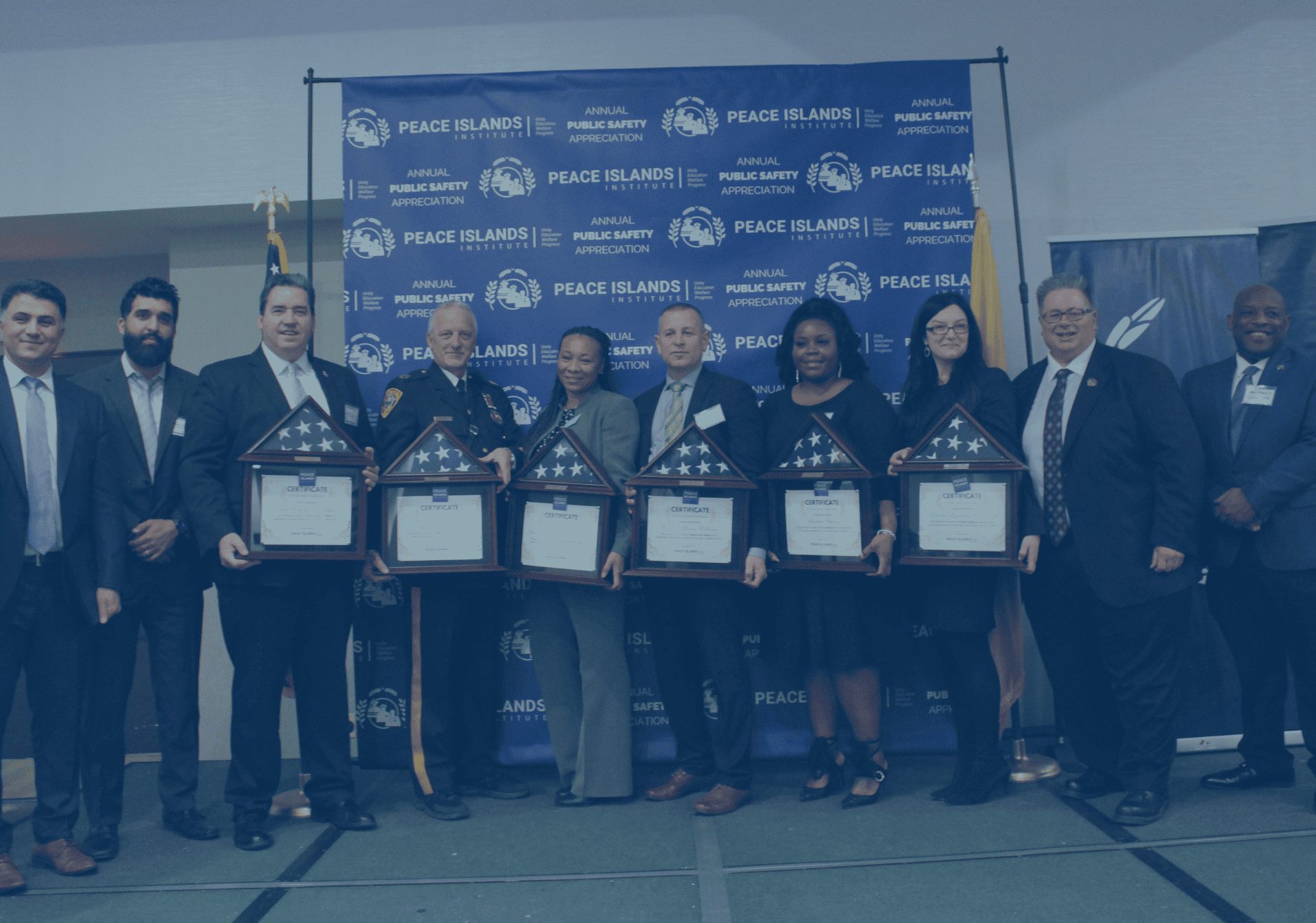 Award recipients hold framed awards in front of a Public Safety Appreciation banner